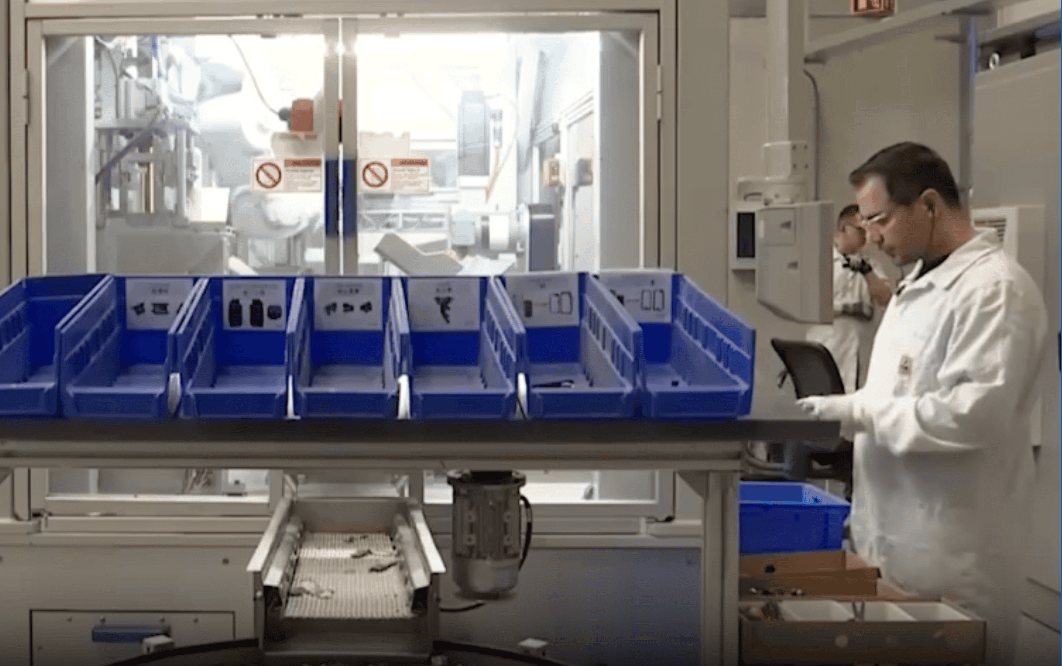 Tiago Lopes inspecting or working on a production line in a modern industrial setting.